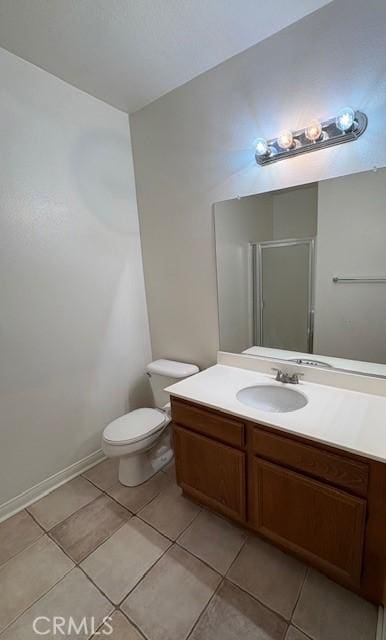 bathroom with toilet, tile patterned flooring, a shower with door, and vanity