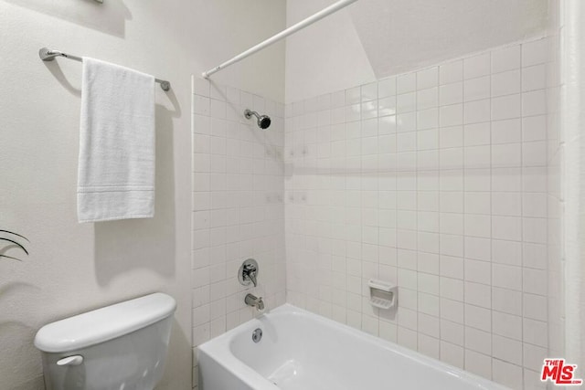 bathroom featuring shower / tub combo and toilet