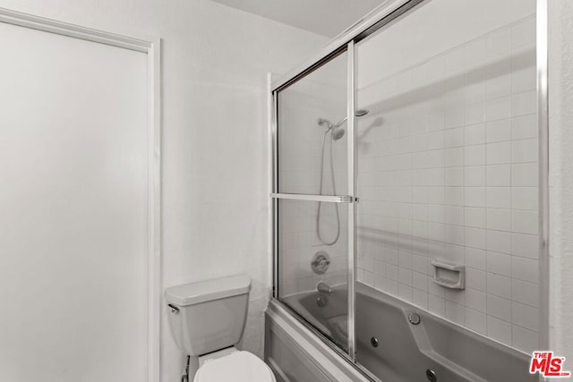 bathroom featuring combined bath / shower with glass door and toilet