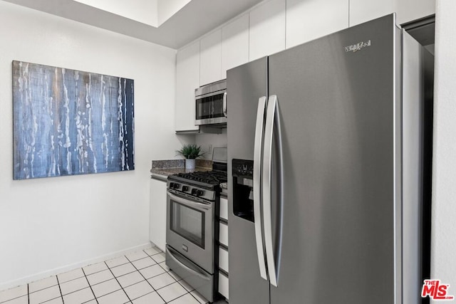 kitchen with white cabinets, stainless steel appliances, and light tile patterned floors