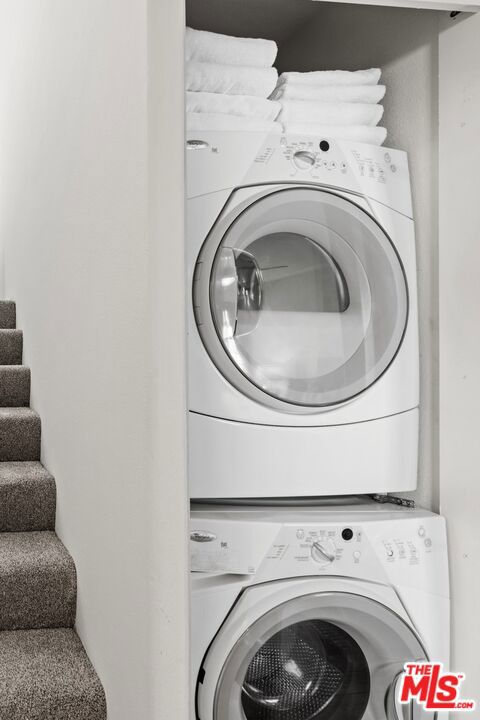 washroom featuring stacked washer / drying machine