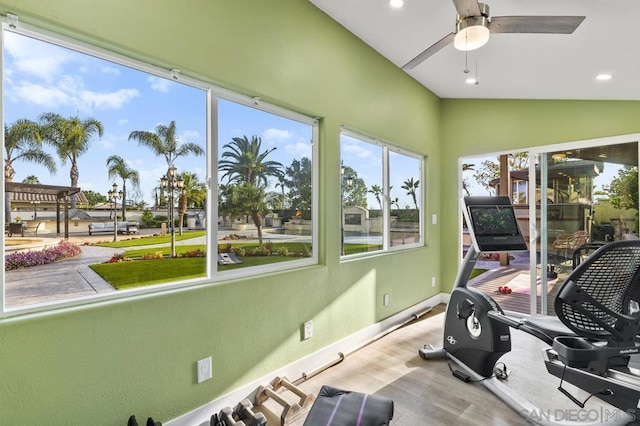 workout room with lofted ceiling, light wood-type flooring, ceiling fan, and plenty of natural light