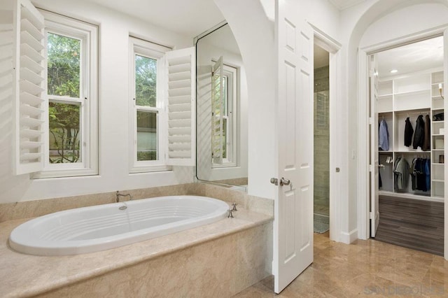 bathroom featuring a relaxing tiled tub