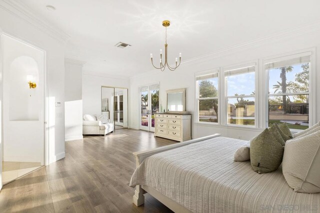 bedroom with a closet, crown molding, a chandelier, and hardwood / wood-style flooring