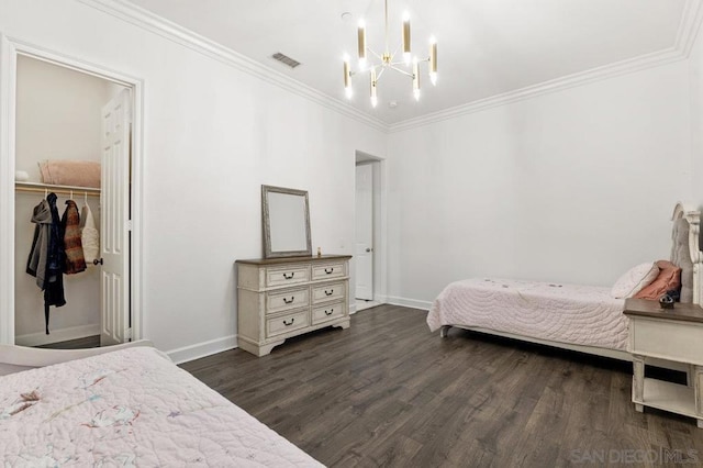 bedroom featuring a spacious closet, a chandelier, dark hardwood / wood-style floors, a closet, and crown molding