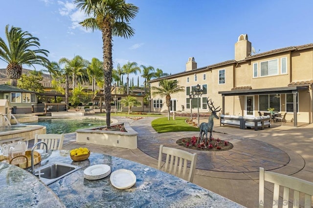 exterior space with a swimming pool, a patio area, and sink