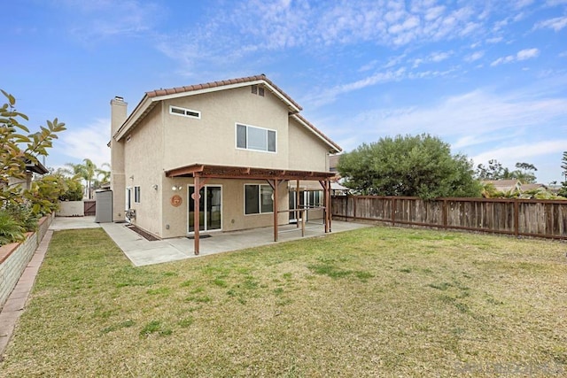 back of house with a patio area and a yard