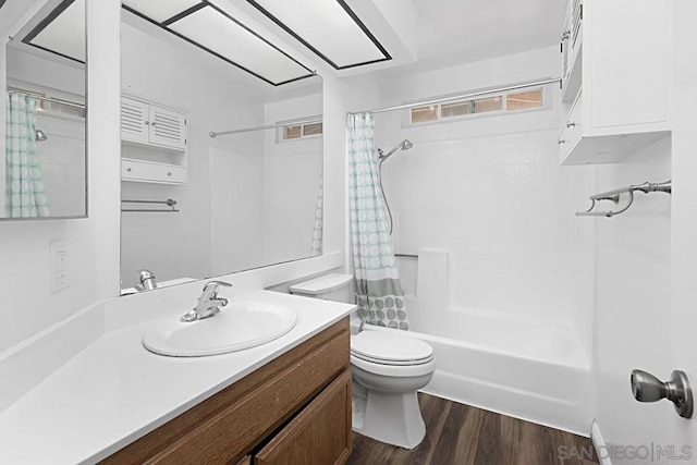 full bathroom featuring hardwood / wood-style floors, toilet, vanity, and shower / tub combo