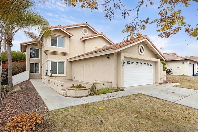 mediterranean / spanish home featuring a garage and a front yard