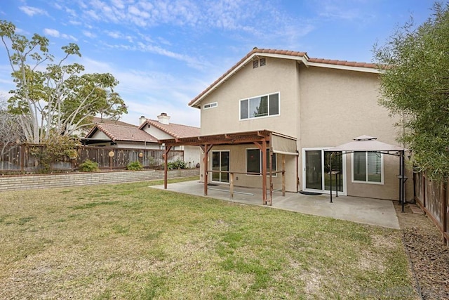 rear view of house with a gazebo, a patio area, and a yard