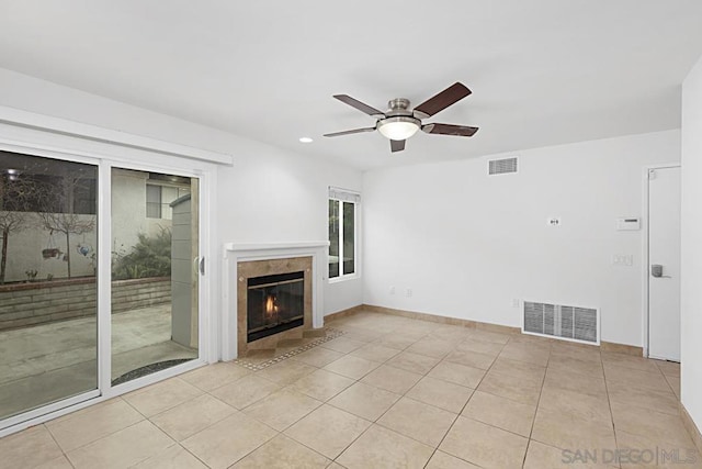 unfurnished living room with a premium fireplace, light tile patterned flooring, and ceiling fan