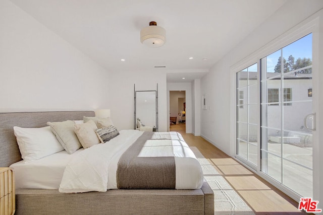 bedroom with light wood-type flooring and access to exterior