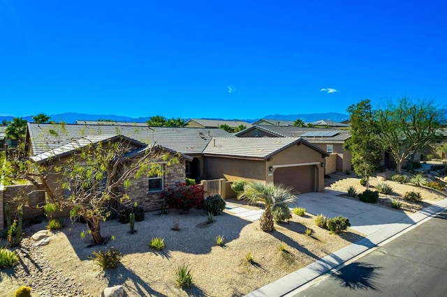 ranch-style home featuring a garage and a mountain view