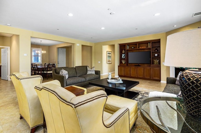 living room featuring an inviting chandelier and built in shelves