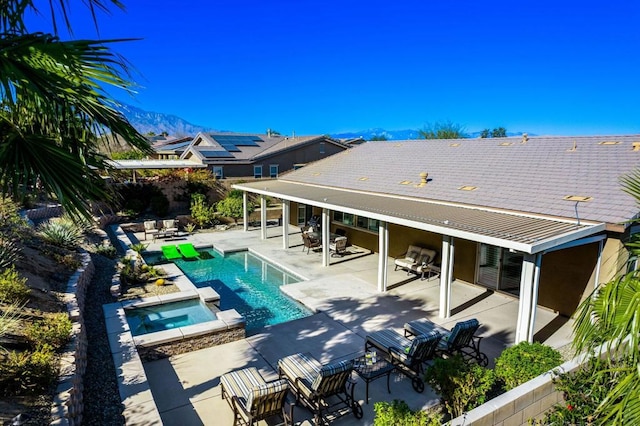 back of house featuring a pool with hot tub and a patio area