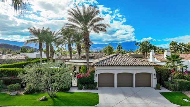 mediterranean / spanish-style house featuring a front lawn, a garage, and a mountain view