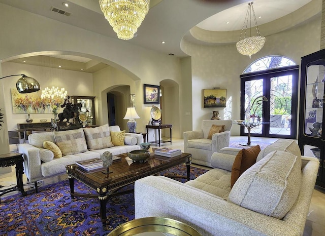 living room featuring a high ceiling, a notable chandelier, and french doors