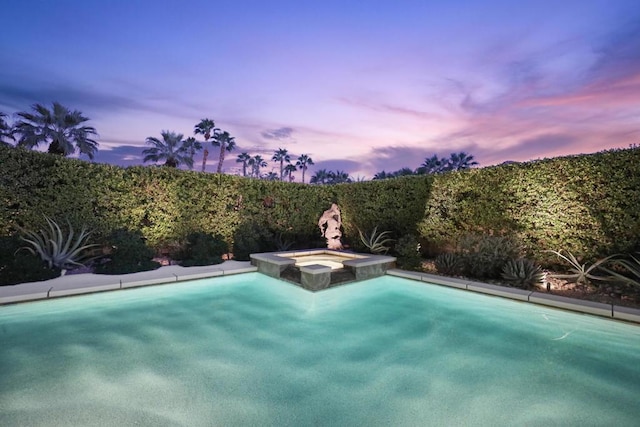 pool at dusk with an in ground hot tub