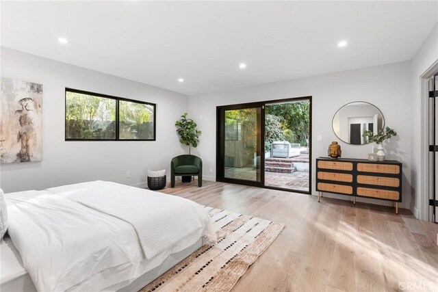 bedroom featuring access to exterior, multiple windows, and light wood-type flooring