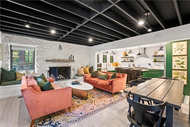 living room featuring hardwood / wood-style flooring and a stone fireplace