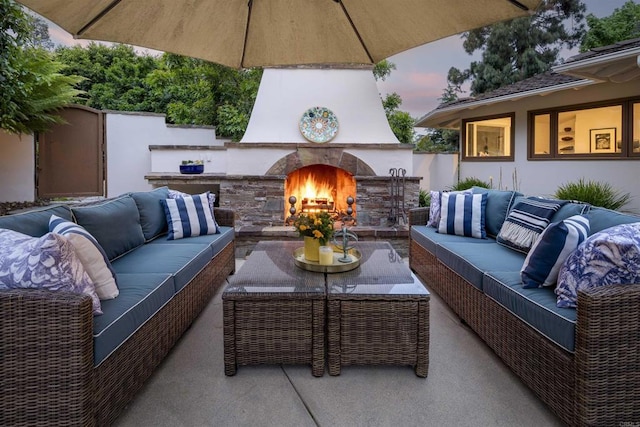 patio terrace at dusk with an outdoor living space with a fireplace