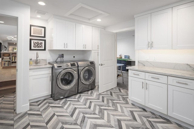 clothes washing area with sink, cabinets, and independent washer and dryer