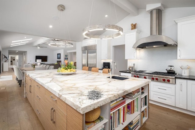 5041 El Secreto, Rancho Santa Fe, CA 92067 - kitchen with stainless steel appliances, a sink, wall chimney range hood, open shelves, and an island with sink