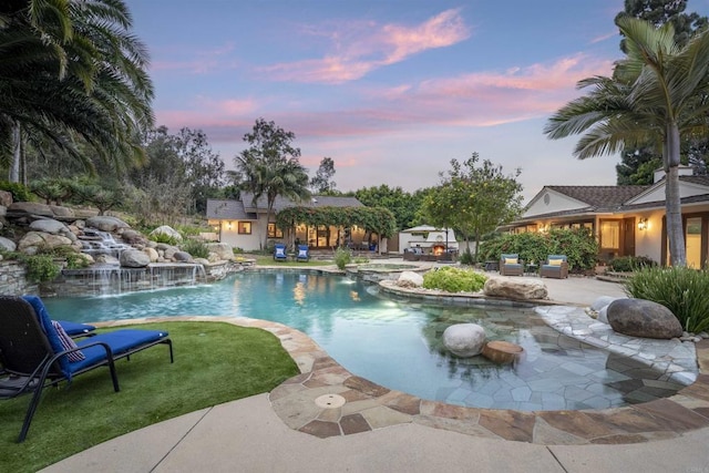 5041 El Secreto, Rancho Santa Fe, CA 92067 - pool at dusk with a patio, an outdoor structure, a pool with connected hot tub, a storage structure, and a lawn