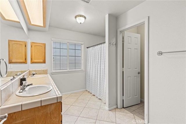 bathroom with vanity, tile patterned flooring, and a skylight