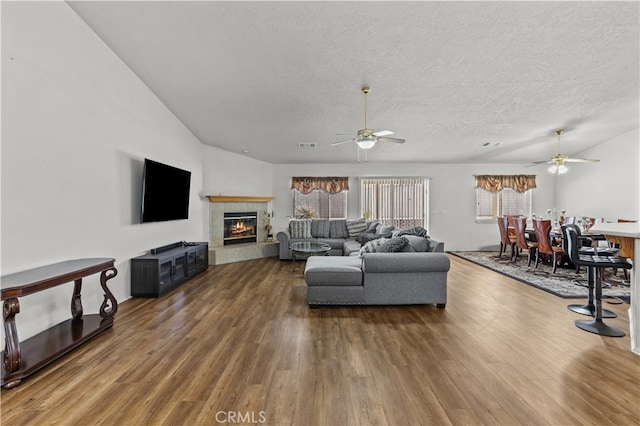 living room featuring ceiling fan, a fireplace, and dark hardwood / wood-style floors