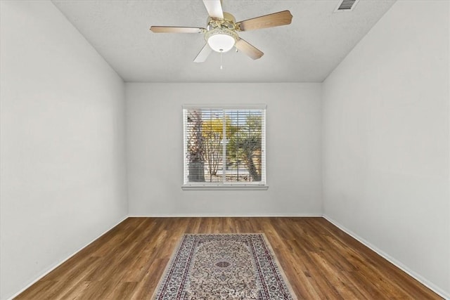 spare room with dark wood-type flooring and ceiling fan