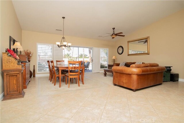 tiled dining area featuring vaulted ceiling and ceiling fan with notable chandelier