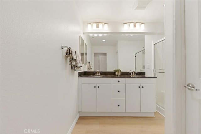 bathroom with vanity, walk in shower, and hardwood / wood-style flooring