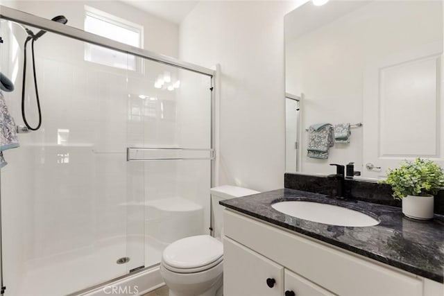 bathroom featuring walk in shower, vanity, and toilet