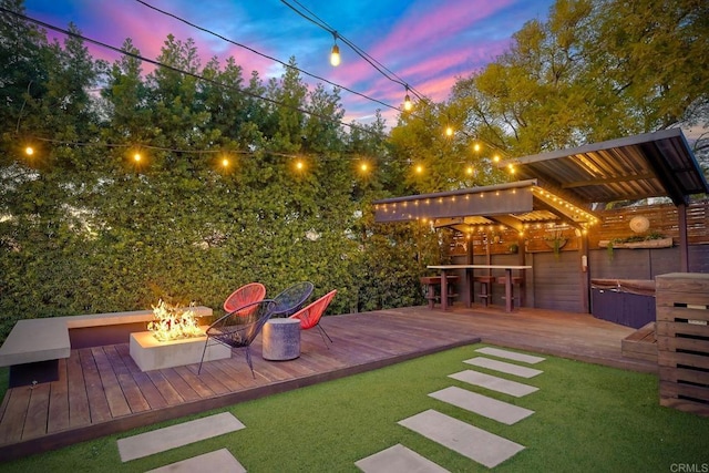 yard at dusk with a deck and an outdoor fire pit