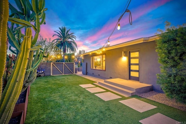 view of yard with a patio area, fence, and a gate