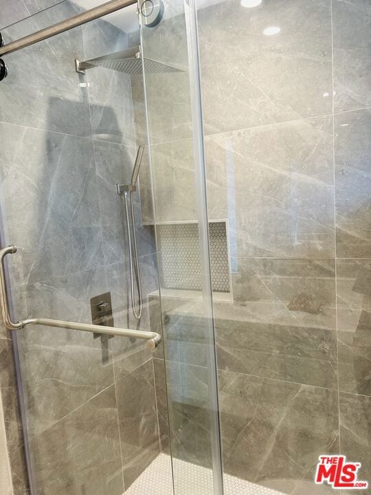 bathroom with a shower with door