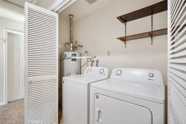 laundry room with washing machine and clothes dryer, secured water heater, and light colored carpet