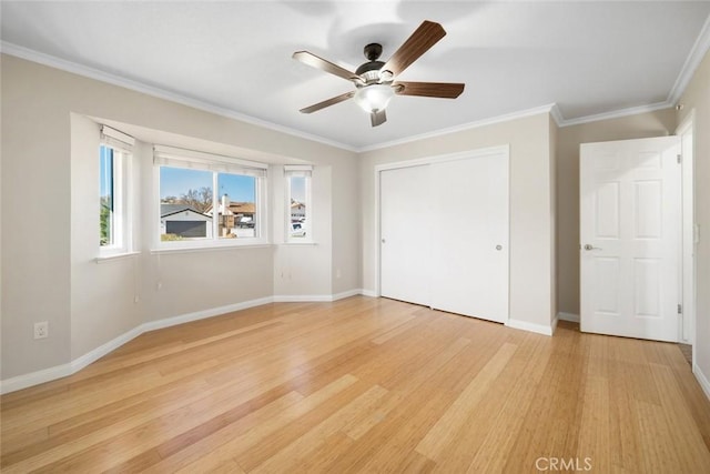 unfurnished bedroom with ceiling fan, light wood-type flooring, a closet, and crown molding