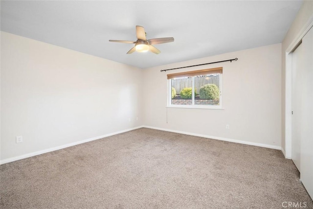 carpeted spare room featuring ceiling fan