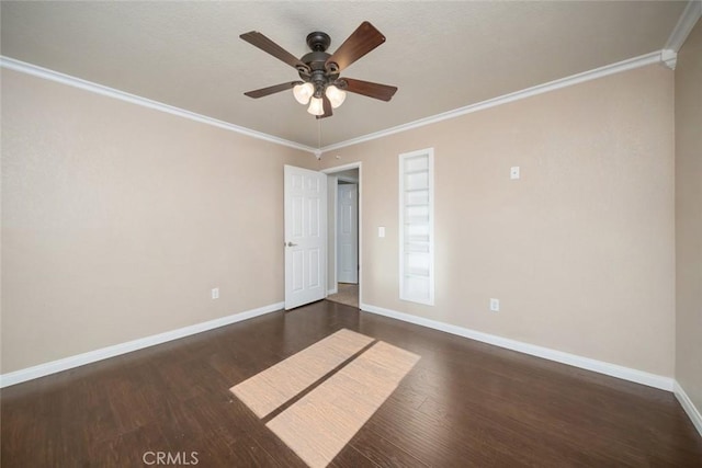 empty room featuring ceiling fan, ornamental molding, and dark wood-type flooring