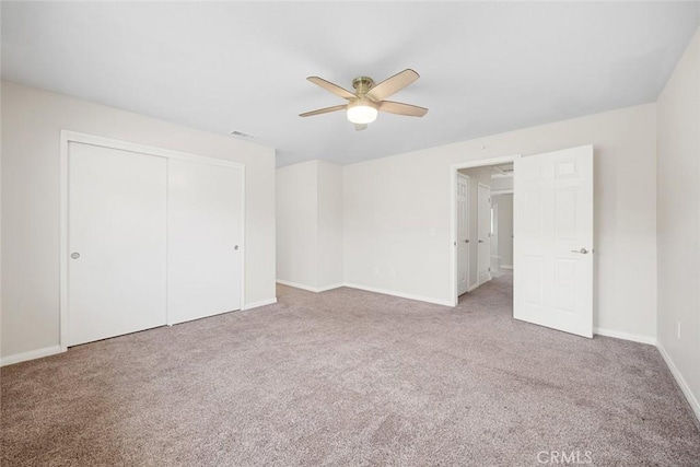 unfurnished bedroom featuring ceiling fan, a closet, and carpet floors