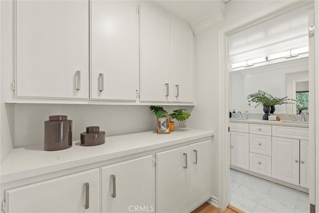 bar with white cabinets and sink