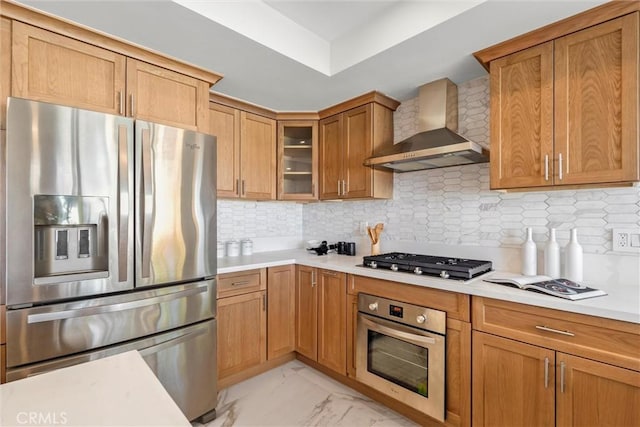 kitchen with appliances with stainless steel finishes, tasteful backsplash, and wall chimney exhaust hood