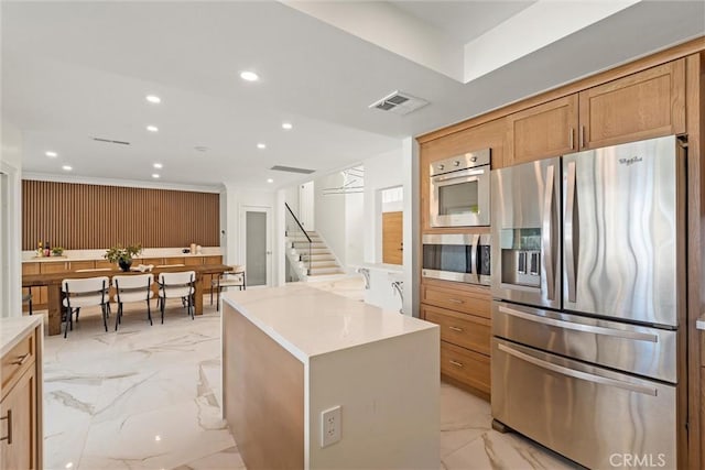 kitchen featuring stainless steel appliances, wood walls, and a center island