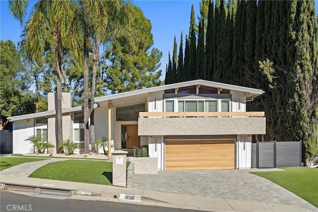 contemporary house featuring a front yard and a garage