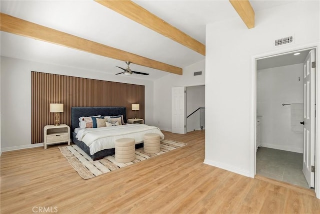 bedroom featuring light hardwood / wood-style floors and lofted ceiling with beams