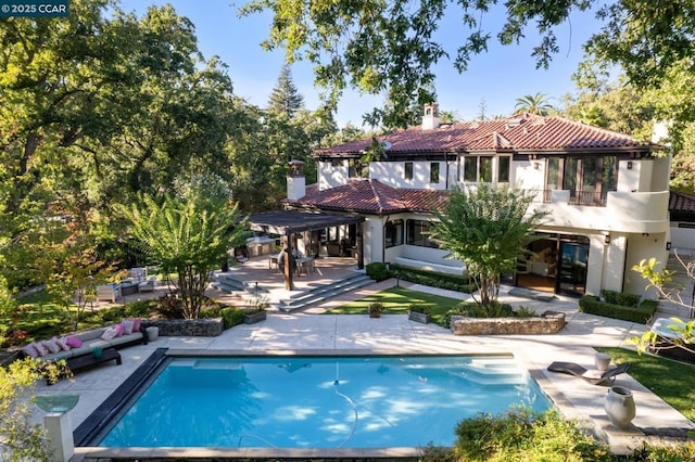 back of property with a balcony and a patio