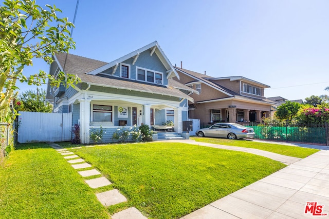 craftsman-style home with covered porch and a front lawn