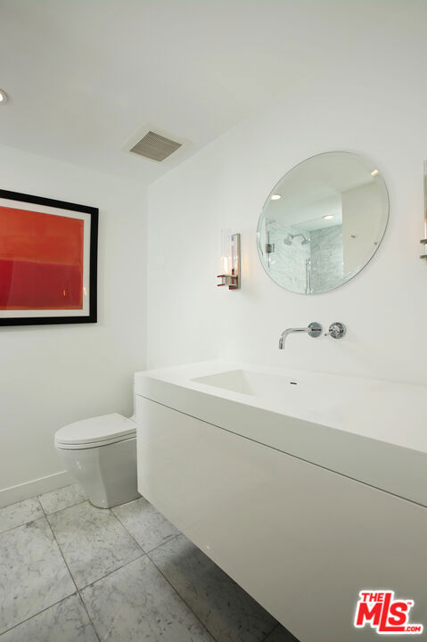 bathroom featuring vanity, tile patterned floors, and toilet